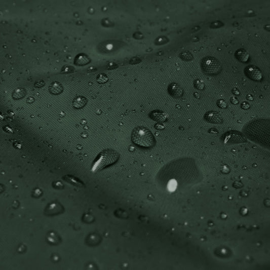Detalle del tejido impermeable del cortavientos KÖNE verde oscuro con gotas de agua.