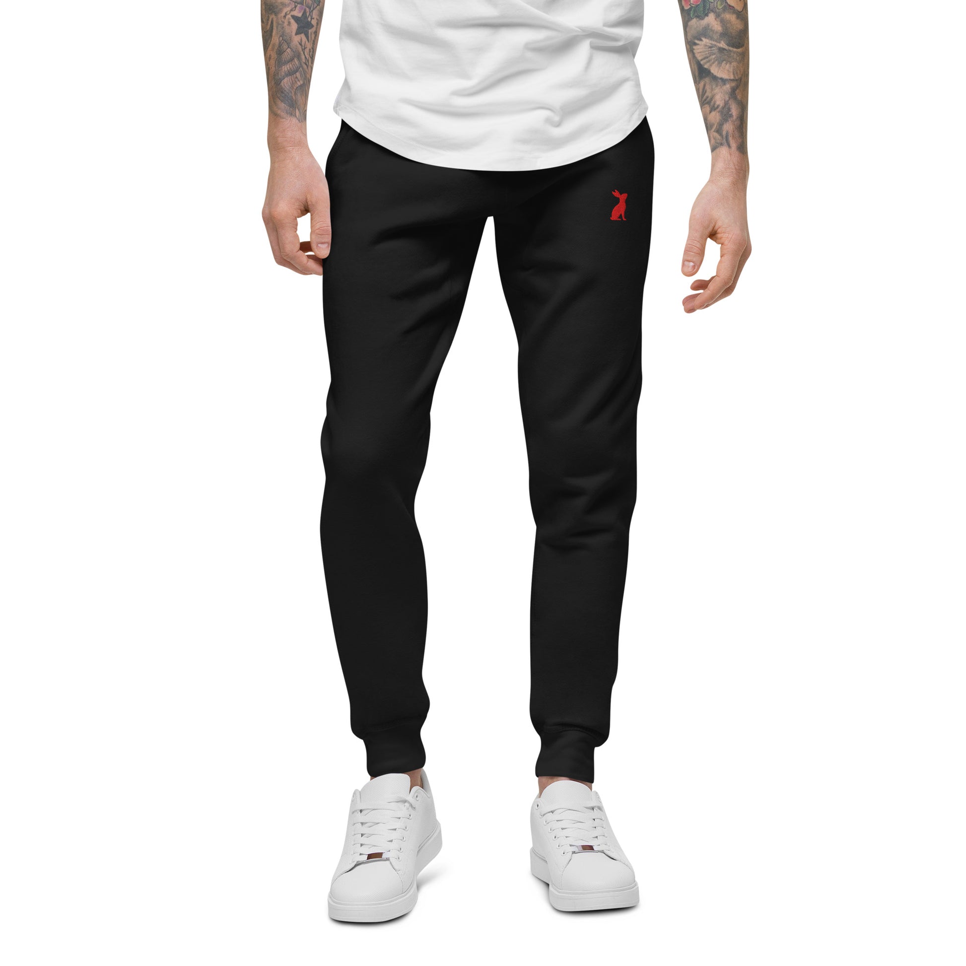 Modelo masculino con pantalón KÖNE negro unisex y camiseta beige, corte recto y cómodo.