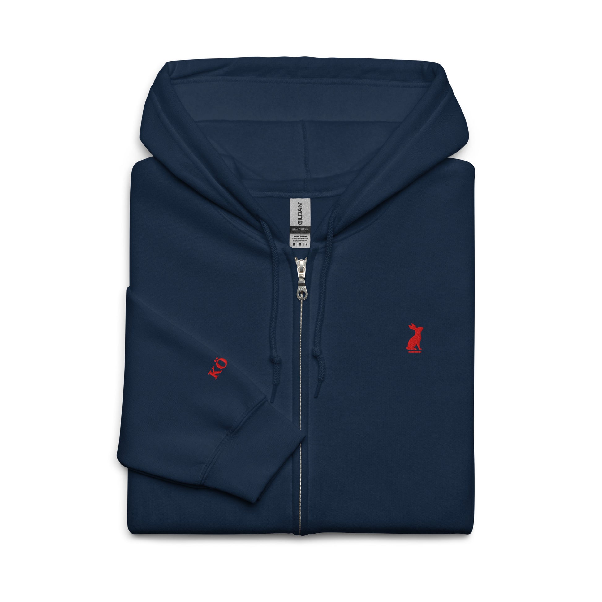Sudadera KÖNE azul marino doblada, muestra el cierre de cremallera y el logo dorado.