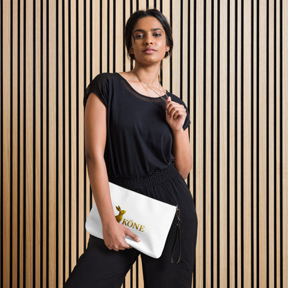 Modelo con bolso con correa KÖNE en piel sintética color blanco, sobre fondo de madera vertical. Diseño minimalista y elegante.